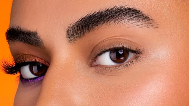 A macro frame of a copper and plum eye with a violet lower line.