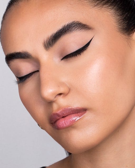 A three-quarter beauty portrait of a graphic black winged liner.