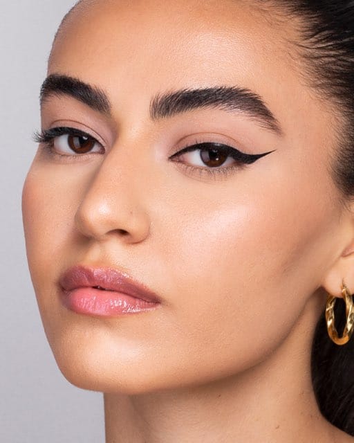 A beauty portrait with the eyes closed, showing the finished liner on both lids.