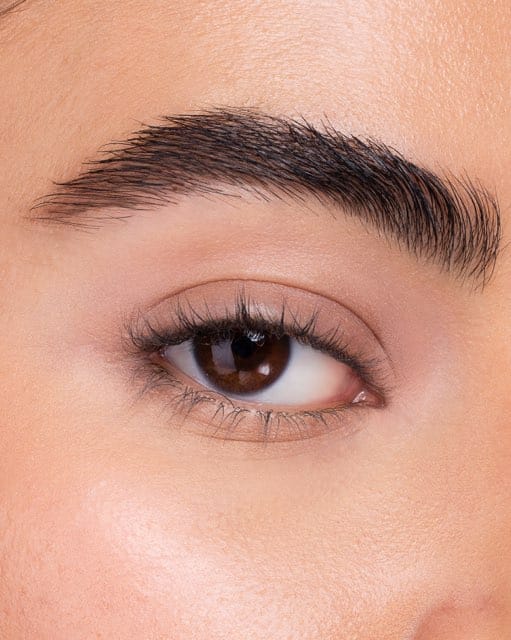 Step one of an eyeliner sequence: a bare lid and brow before any product.